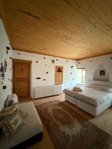 a bedroom with a large bed and a wooden ceiling at Osmanil Konağı Sarıhacılar in Sarıhacılar