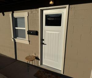 a white door and a stool next to a brick wall at Carolina Suite in Chester