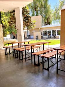 a group of picnic tables and benches under a building at Complejo Turístico Mendoza in Godoy Cruz