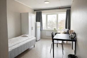 a bedroom with a bed and a table and a dining room at Rygge Apartments in Moss