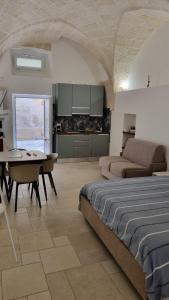 a bedroom with a bed and a table and a kitchen at Maredì Brindisi vacation home in Brindisi