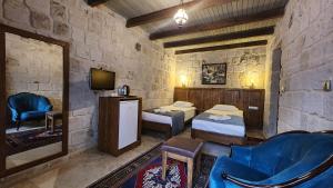 a room with two beds and a tv in it at Yıldız Hotel in Ürgüp