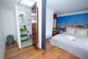a bedroom with a large white bed and a bathroom at Large 1-Bedroom 1 Doble bed 1 Sofa bed 1 Bathroom Duplex Apartment Prime Lisbon Location in Lisbon