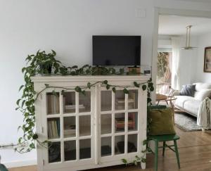 a living room with a white cabinet with a tv on it at Oasis de Sal y Pradera in Miengo