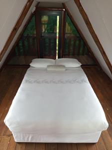 a large white bed in the attic of a room at Stush In the Bush in Stegi