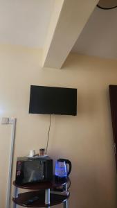 a microwave and a tv on a table at Sky Nest 14 in Nairobi +3 photos