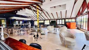 a large room with tables and chairs and windows at Stush In the Bush in Stegi