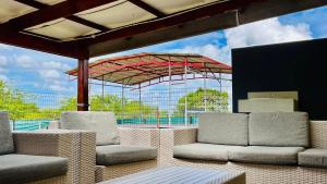 a patio with chairs and a red umbrella at Stush In the Bush in Stegi