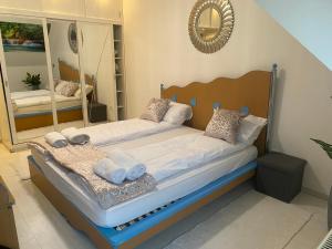 a bedroom with a bed with towels and a mirror at Central Vibe Apartman in Kecskemét +16 photos