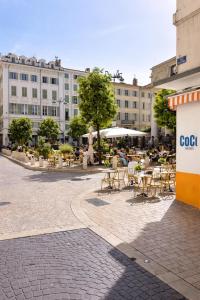 a courtyard with tables and chairs and a building at La Chic Opéra - à 30 secondes min du Vieux-Port- Clim in Marseille