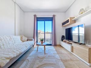 a living room with a couch and a flat screen tv at San Pedro Centro - 9110 in San Pedro del Pinatar
