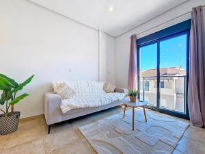 a living room with a couch and a large window at San Pedro Centro - 9110 in San Pedro del Pinatar