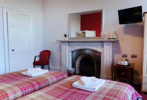 a bed room with two beds and a fireplace at Regent House Hotel - City Centre Hotel in Edinburgh