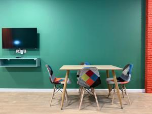 a table and chairs in a room with a tv at Premium New Gudauri Apartments with Balcony & Gondola Views in Gudauri