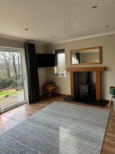 a living room with a rug and a large window at Coiseag at Maol Ruadh, Roy Bridge, near Ben Nevis in Roybridge