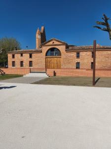 a brick building with a wooden gate in front of it at Violette in Bazus