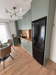 a kitchen with a large black refrigerator in a room at Apartament Eroilor Residence in Floreşti