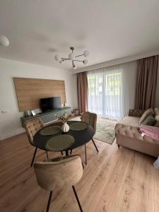 a living room with a table and chairs and a couch at Apartament Eroilor Residence in Floreşti