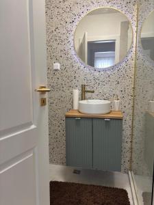 a bathroom with a sink and a mirror at Apartament Eroilor Residence in Floreşti