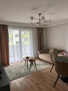 a living room with a couch and a table at Apartament Eroilor Residence in Floreşti +3 photos