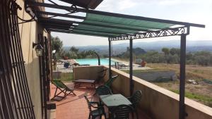 un patio con sillas, una mesa y una piscina en Le Querce, en Campiglia Marittima