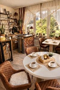 a room with tables and chairs and a kitchen at Hotel Elisabeth Ilse in Braunlage