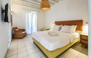 a bedroom with a large white bed and a chair at Bella Alba in Kalafatis +40 photos