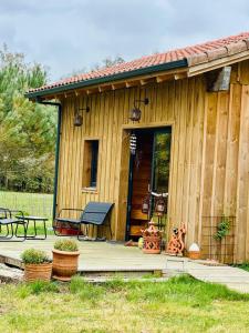 a small wooden cabin with a porch and a bench at cab Anne in Léon