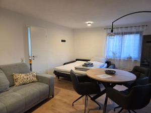 a living room with a couch and a table and a bed at Ferienwohnung Waldenburg Sachsen II in Waldenburg +9 photos