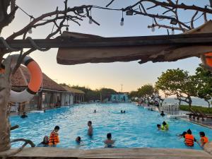a group of people in a swimming pool at a resort at Ana resort Phu Yen in Liên Trì (4) +8 photos