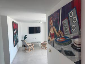 a living room with a large painting on the wall at Hostel La Catalina Plus - frente al mar in Cartagena de Indias
