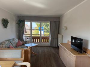 a living room with a couch and a television at Gasthof Rössle in Sulzberg