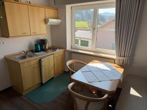 a small kitchen with a table and a sink at Gasthof Rössle in Sulzberg