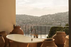 a bath tub in front of a window with vases at Rose Bank in Johannesburg