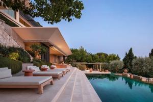 a pool with lounge chairs next to a building at Rose Bank in Johannesburg