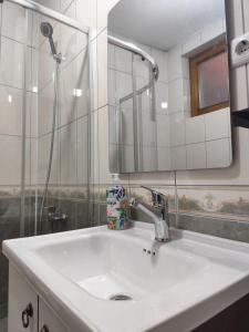 a bathroom with a white sink and a mirror at White Apartment in Prizren +90 photos