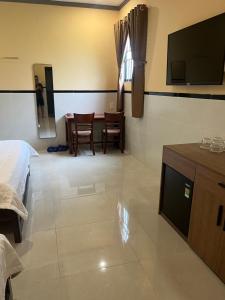 a room with a bed and a television and a table at Khách Sạn 68 Trần Đề in Ấp Nhà Việc