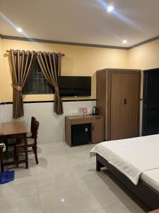 a bedroom with a bed and a table and a kitchen at Khách Sạn 68 Trần Đề in Ấp Nhà Việc