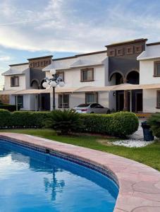 a house with a swimming pool in front of it at Arroyos del Paraíso Residencial Suite A in Manuel F. Martínez +3 photos
