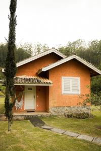 a small orange house with a white door at Pousada do Nonno in Venda Nova do Imigrante