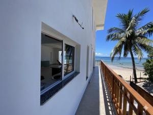 a balcony of a house with a view of the beach at Villalola in Nosy Be