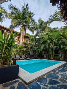 a pool in front of a resort with palm trees at Casa Juntos by Villa Eden in Palomino