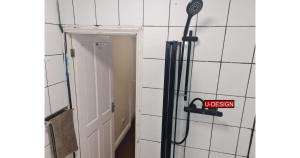 a shower in a bathroom with a sign on the wall at Parkside Studio in Luton +62 photos