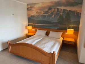 a bedroom with a bed with a painting on the wall at Gasthof Rössle in Sulzberg