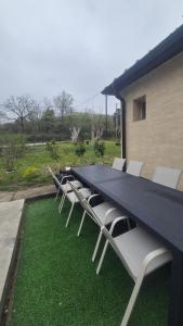 a long table with white chairs sitting on the grass at Konak Jugovo in Smederevo