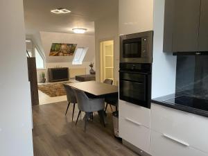 a kitchen and dining room with a table and appliances at Central Vibe Apartman in Kecskemét