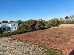 an old brick road with a house in the background at The Lookout in Pearly Beach