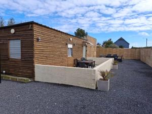 a wooden building with a table and a patio at La jonquiere etablisement climatisé in Landouzy-la-Cour