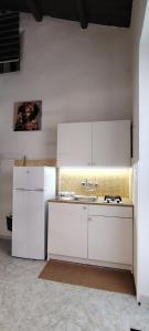 a white kitchen with a sink and a refrigerator at Raggiu di Suli in Noto
