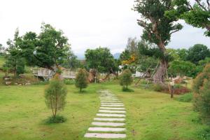 a stepping stones path in a field with trees at The Peak Hill Pool Villa in Ban Wa Kachieo +92 photos